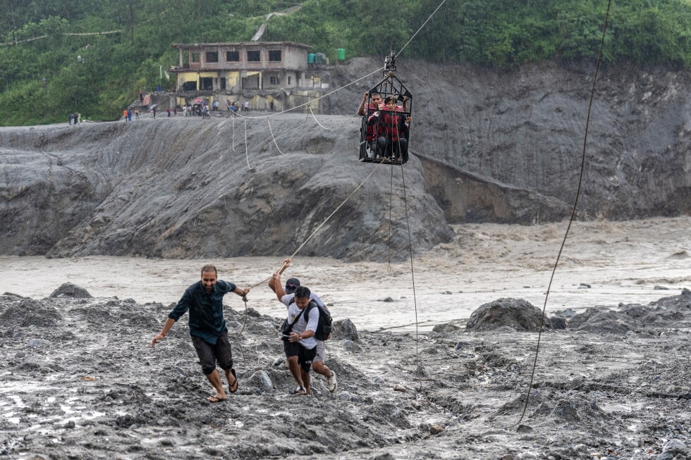 Pics - Nepal flood survivors cross a raging river by makeshift zipline